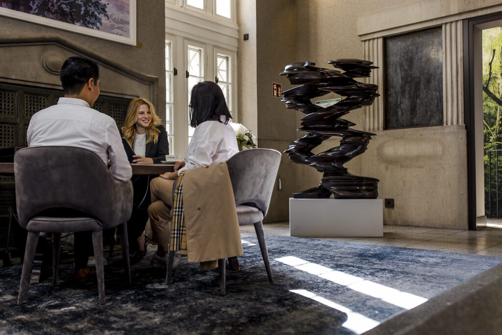 Concierge consultation at The Wellem Hotel in Düsseldorf with two guests in the elegant lounge.