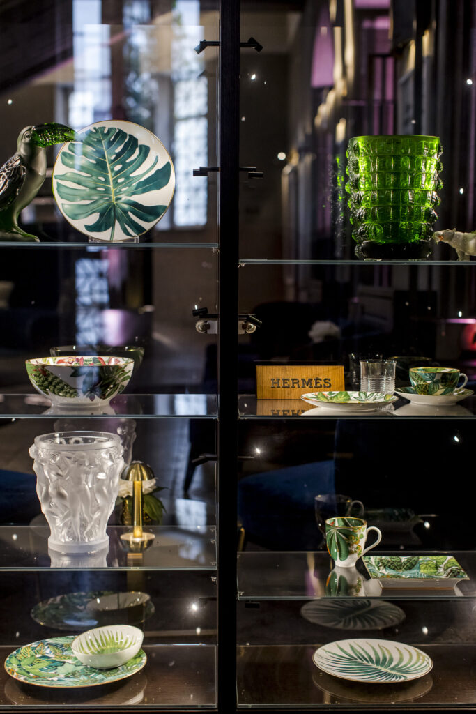Elegante Vitrine mit hochwertigem Hermès-Geschirr und Designobjekten im Hotel The Wellem Düsseldorf.